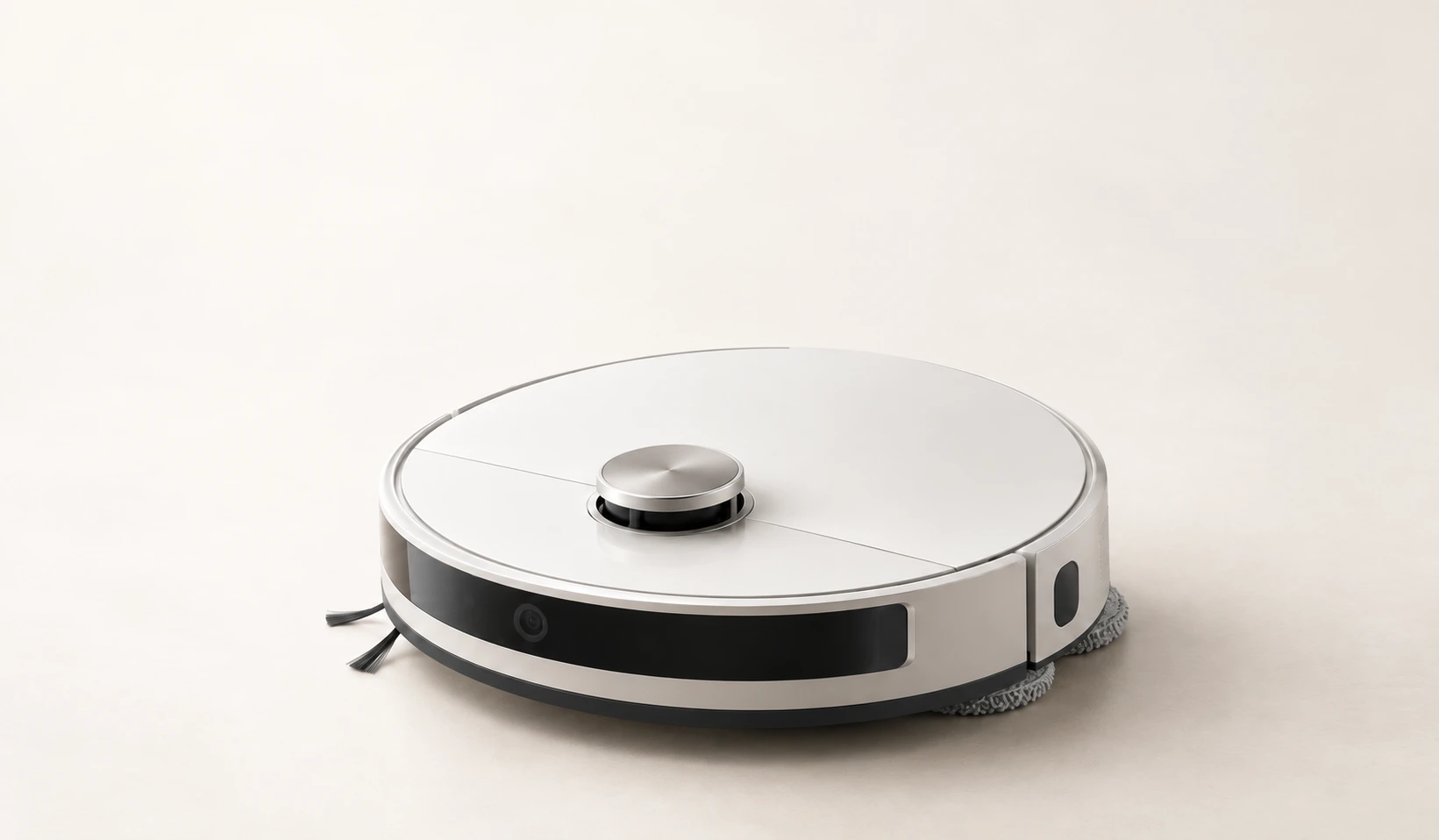 Silver robot vacuum on a softly lit ivory surface